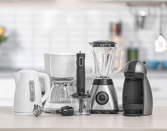 Group of common home appliances on a counter including a blender and coffee maker.