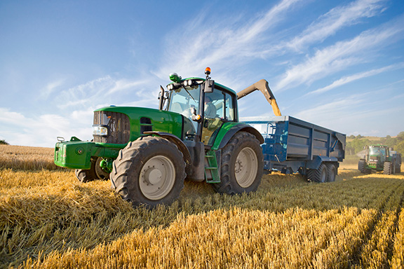 Agricultural tractor harvesting grain.
