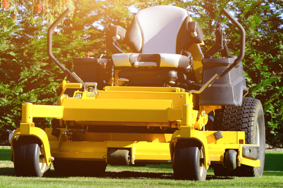 Brand new, yellow, zero-turn riding lawnmower.